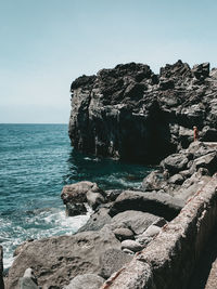 Rock formation on beach against clear sky