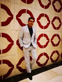 Portrait of young man standing against wall