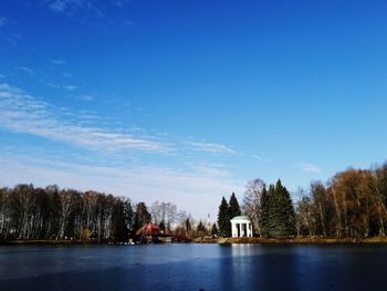 Scenic view of lake by building against blue sky