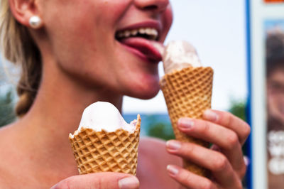 Midsection of woman licking ice cream
