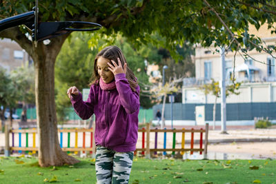 Full length of girl standing against trees