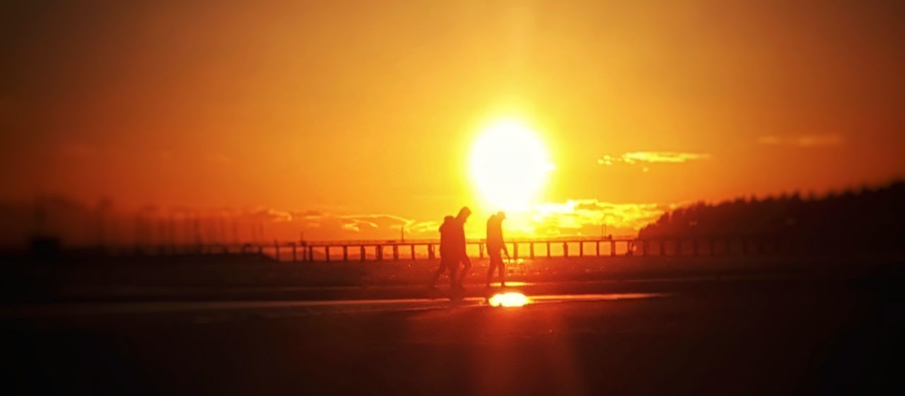 SILHOUETTE WOMAN STANDING ON BEACH DURING SUNSET