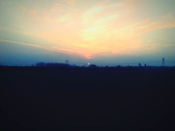 Scenic view of silhouette field against sky at sunset