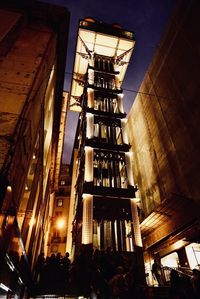 Low angle view of illuminated buildings against sky at night