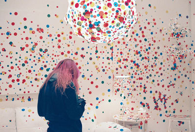 Rear view of woman standing against balloons