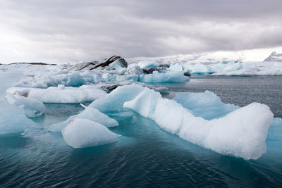 Icebergs floating in jökulsárlón, iceland, during a cloudy day