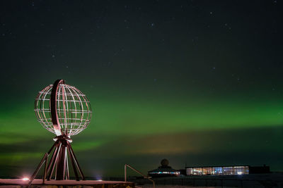 Low angle view of illuminated ferris wheel against sky at night