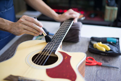 Midsection of woman playing guitar