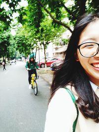Portrait of young woman riding bicycle on street