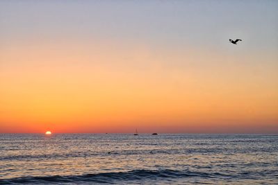 Scenic view of sea against orange sky