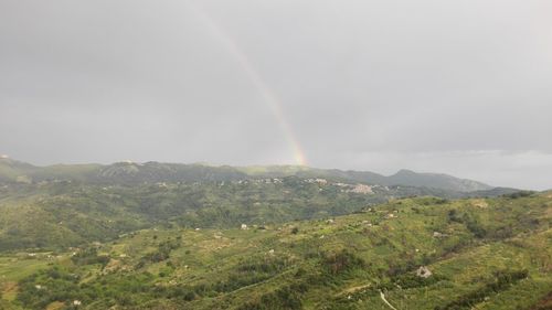 Scenic view of rainbow over landscape against sky