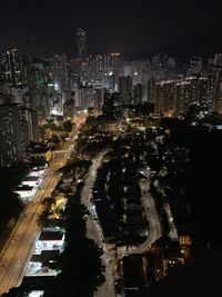 High angle view of illuminated street amidst buildings at night