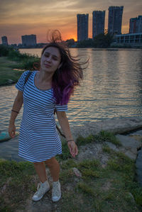 Portrait of woman relaxing in city at sunset