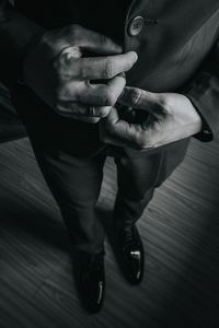 Low section of businessman standing on hardwood floor