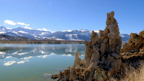 Scenic view of lake and mountains against blue sky