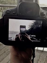 Cropped image of man photographing through smart phone