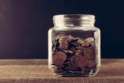 Close-up of coins in jar on table
