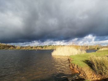 Scenic view of land against cloudy sky