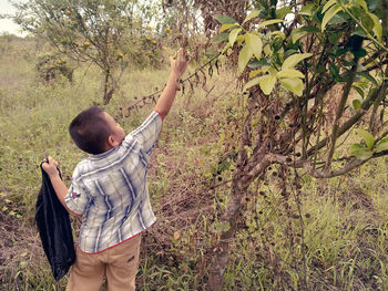 Eye level shot of boy holding plant