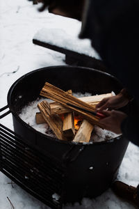 From above camping fireplace with burning firewood in snowy winter day