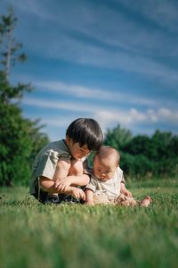 Portrait of boys sitting on field