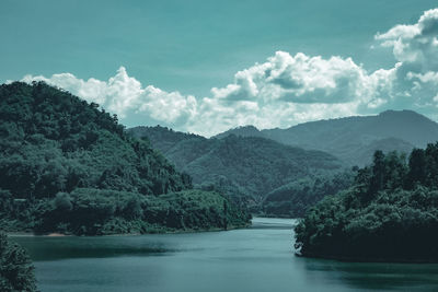 Scenic view of river and mountains against sky