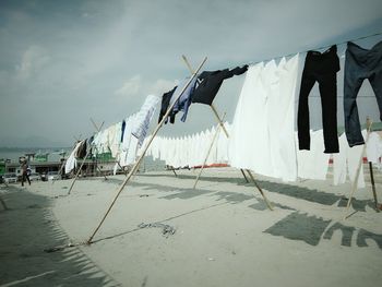 Man walking by clothesline on beach