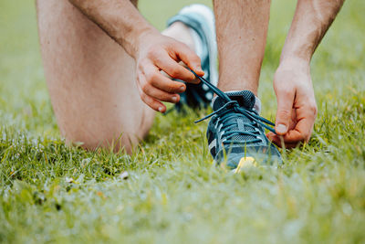 Low section of man tying shoelace outdoors