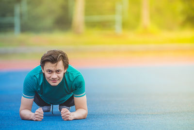 Portrait of young man exercising at stadium