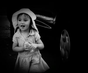 Portrait of cute girl sitting on wall