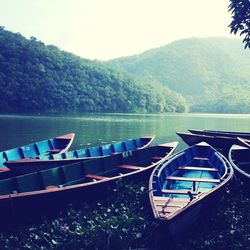 Boats moored in lake against clear sky