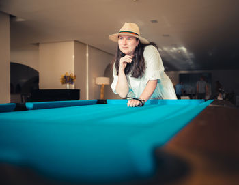 Portrait of young woman playing pool