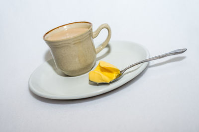 Close-up of tea cup on table against white background