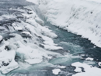 River flowing amidst snowy field during winter