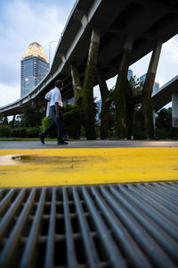 Rear view of man walking on bridge