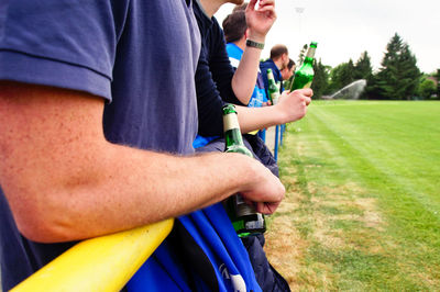 Midsection of man holding beer bottle