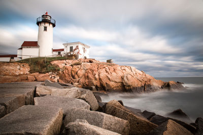 Lighthouse by sea against sky