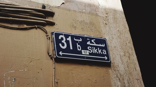 Low angle view of directional sign on wall