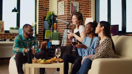 Smiling friends using phone while sitting at restaurant