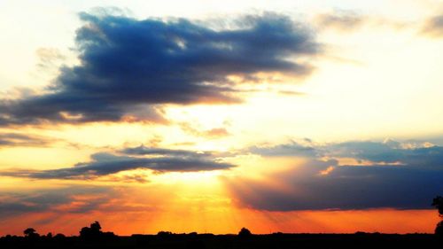 Silhouette of landscape against cloudy sky during sunset