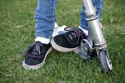 Low section of person on push scooter over grass