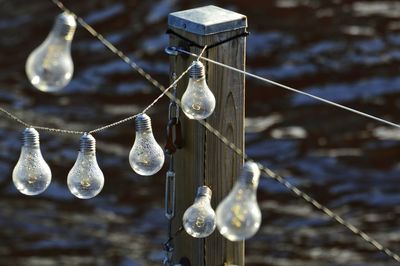 Low angle view of light bulb hanging over water