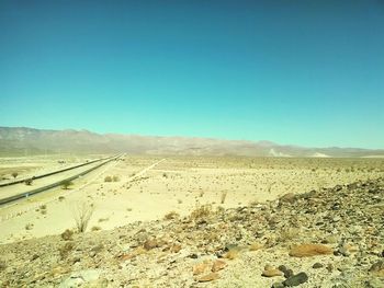 Scenic view of desert against clear blue sky