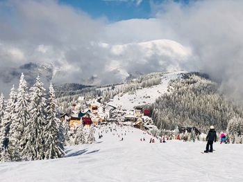 People on snowcapped mountain against sky