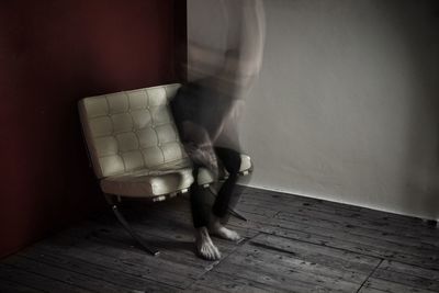 Low section of woman holding wooden floor at home