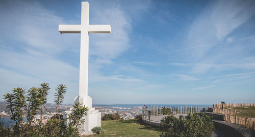 Cross by sea against sky