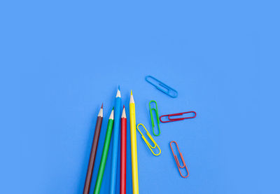 High angle view of colored pencils against blue background