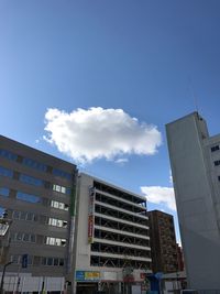 Low angle view of skyscrapers against cloudy sky