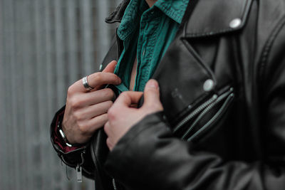 Midsection of man wearing leather jacket