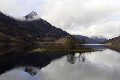 Scenic view of lake by mountains against sky